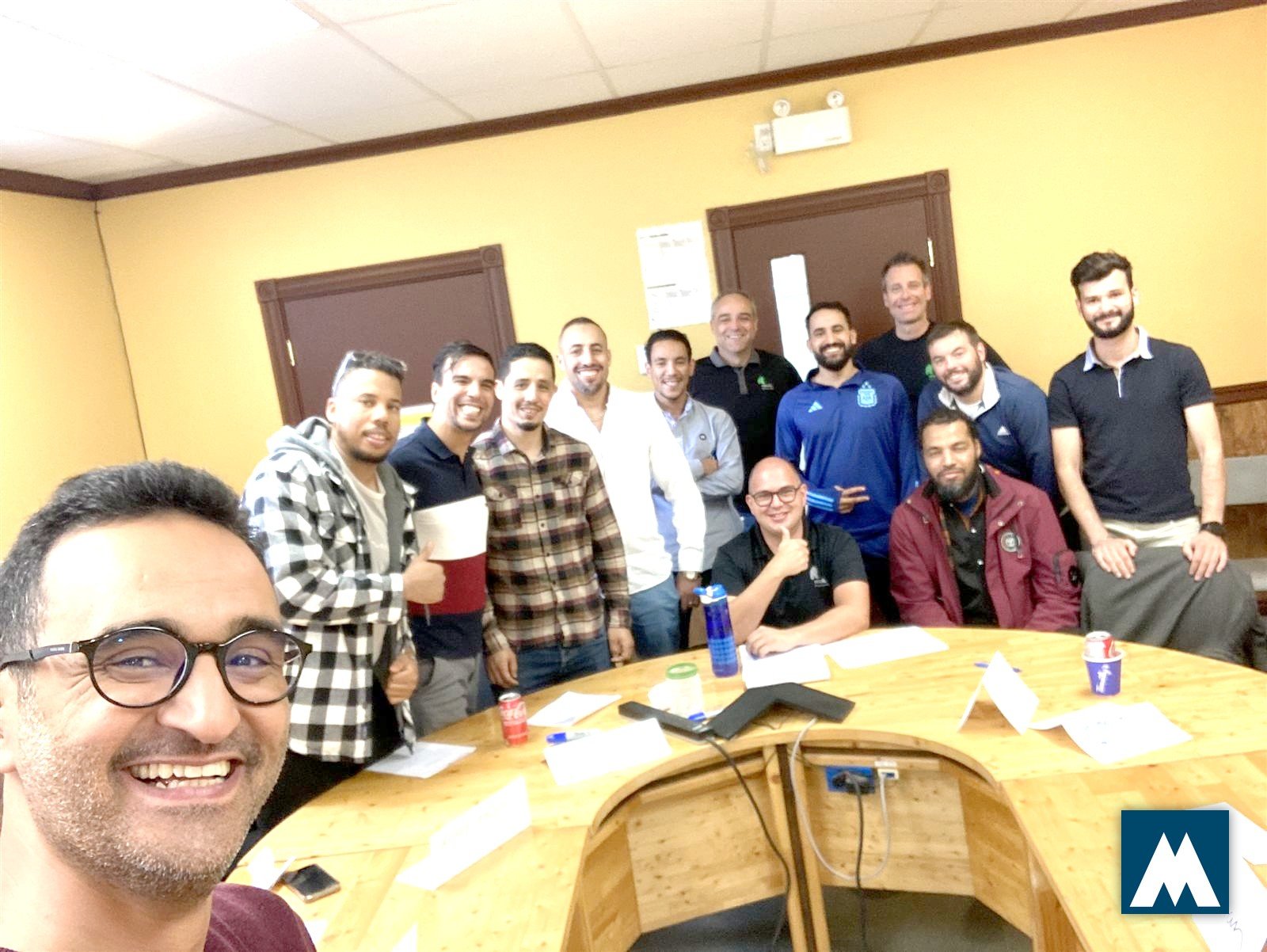 Groupe de travailleurs internationaux réunis autour d'une table lors d'une session Mosaïca